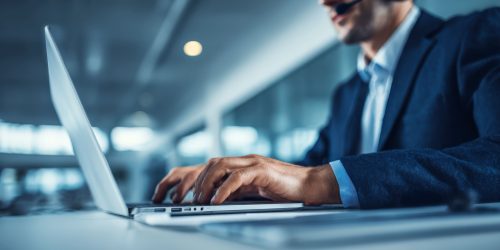 IT support specialist wearing a headset and working on a laptop, representing outsourced help desk services in Central Ontario