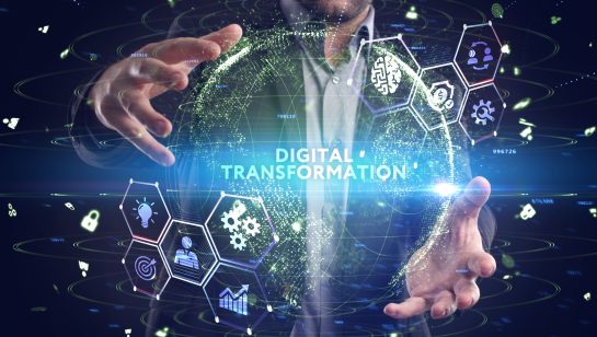 Professional interacting with a virtual screen displaying technology icons and the phrase ‘Digital Transformation,’ representing IT services in Central Ontario