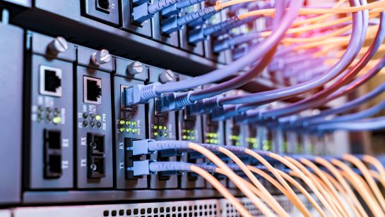 Colorful network cables connected to server racks in a data center, representing a server room infrastructure upgrade case study