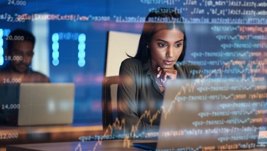 Woman working on laptop with code and financial data overlaid.