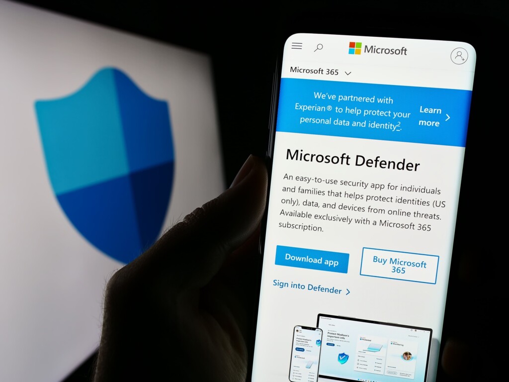 Smartphone screen displaying Microsoft Defender app page with security shield logo in background