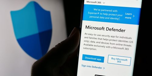Smartphone screen displaying Microsoft Defender app page with security shield logo in background