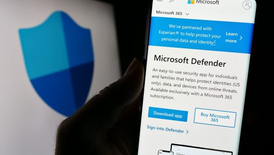 Smartphone screen displaying Microsoft Defender app page with security shield logo in background
