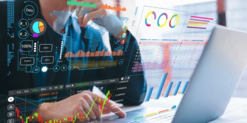 Business professional analyzing digital data dashboards and performance charts on a laptop screen