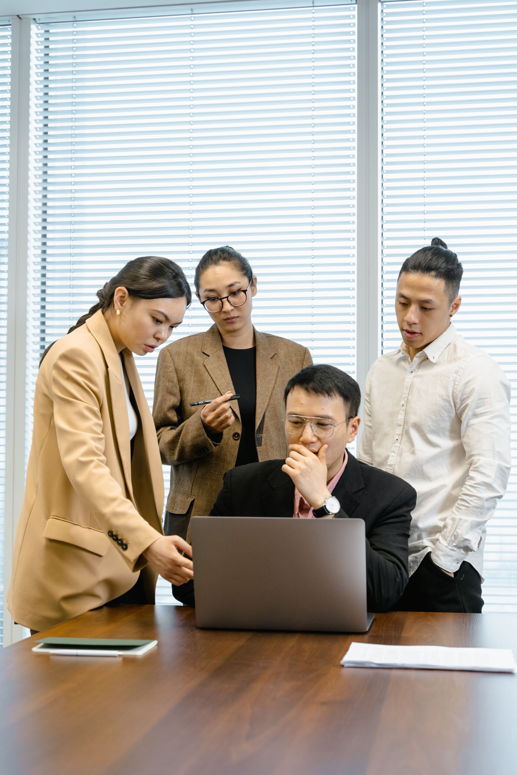 Team collaborating around a laptop reviewing a technology roadmap in a modern office setting