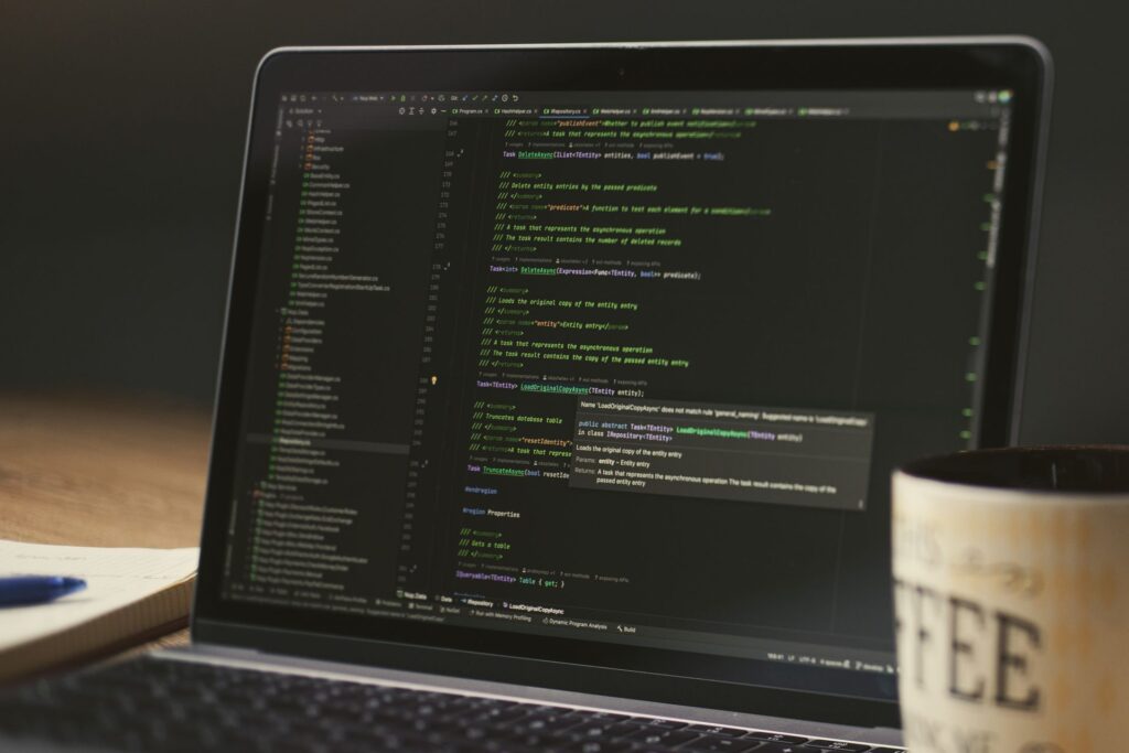 Laptop screen showing code during a late-night coding session, representing the custom reply portal built on the Autotask API
