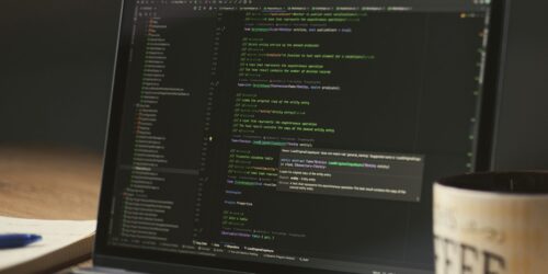 Laptop screen showing code during a late-night coding session, representing the custom reply portal built on the Autotask API
