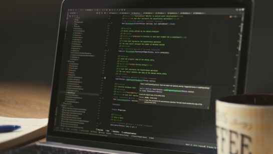 Laptop screen showing code during a late-night coding session, representing the custom reply portal built on the Autotask API