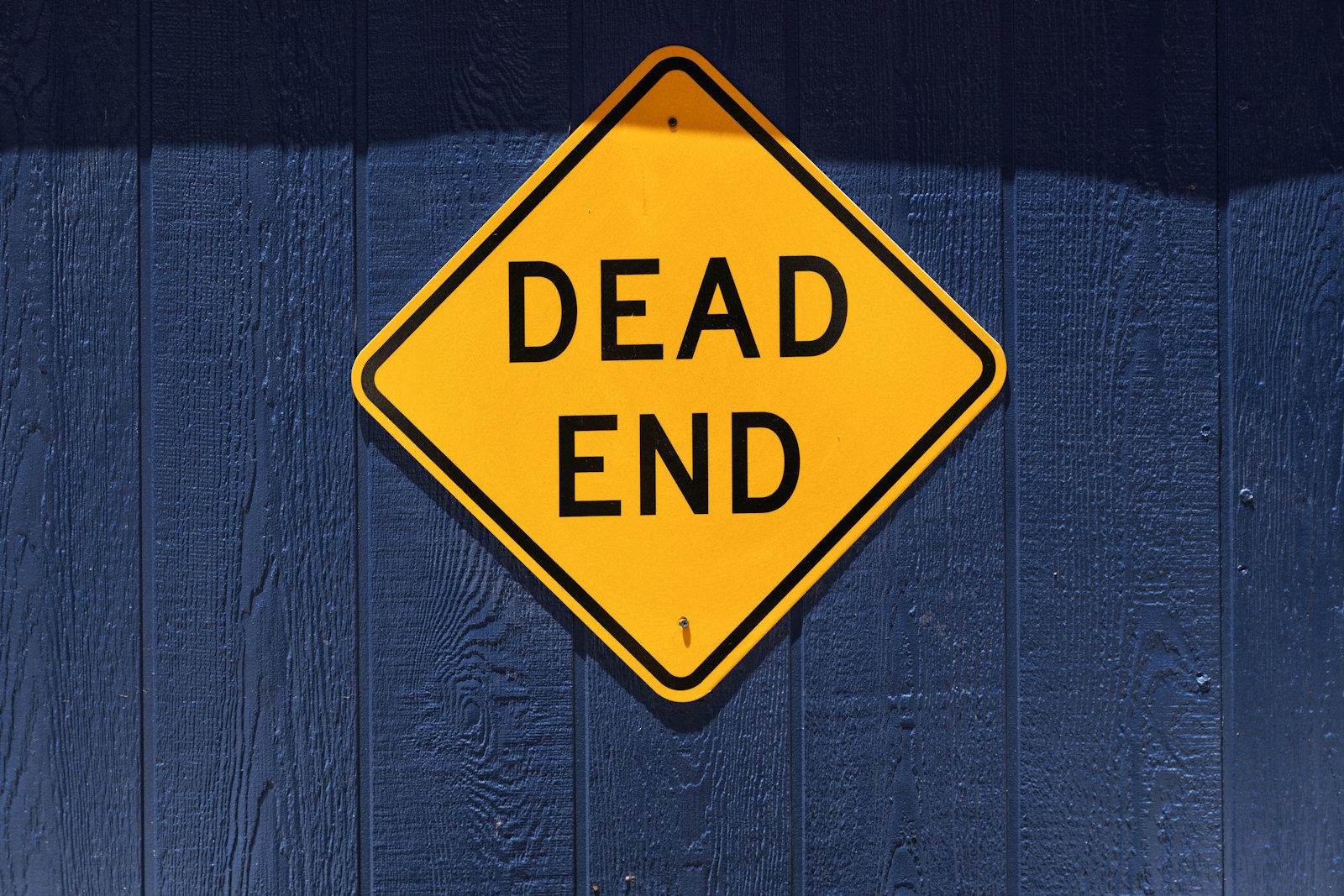A yellow Dead End road sign, representing the line every generous unlimited support contract still draws somewhere