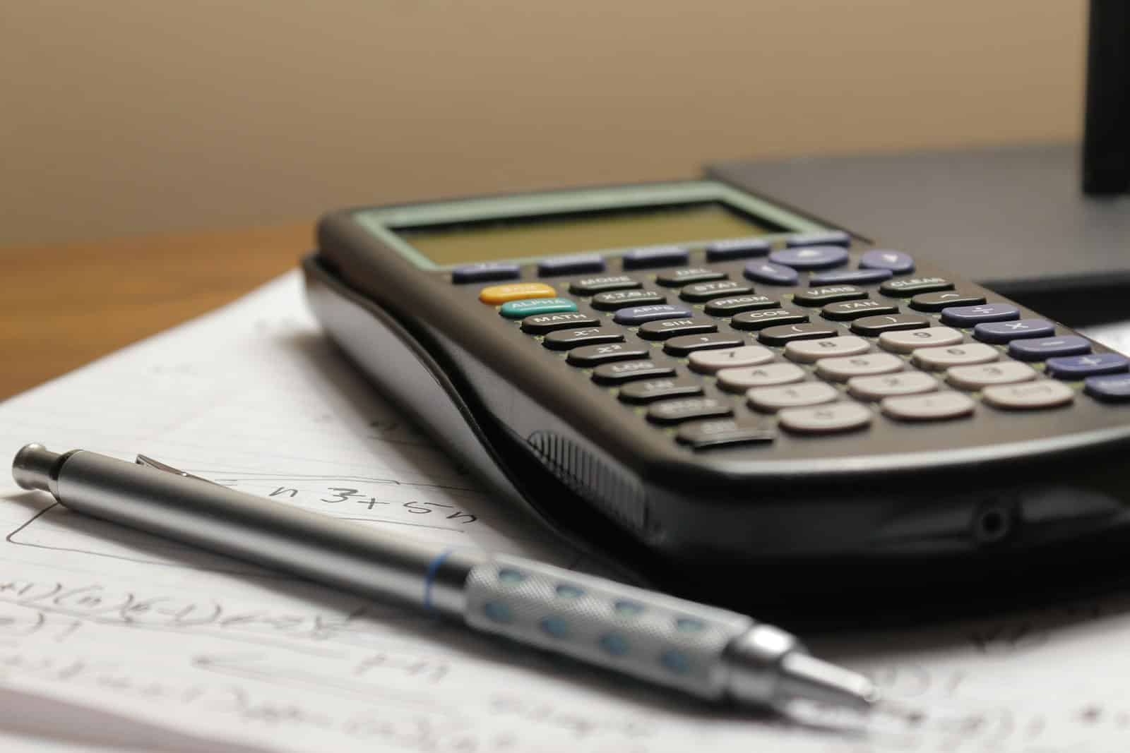 Calculator and pen on paper, representing working out which IT support pricing model actually fits