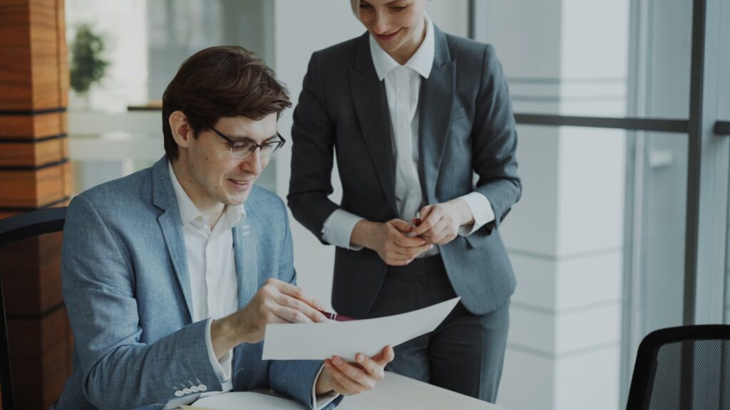 Two business professionals reviewing a managed IT services contract together at a desk