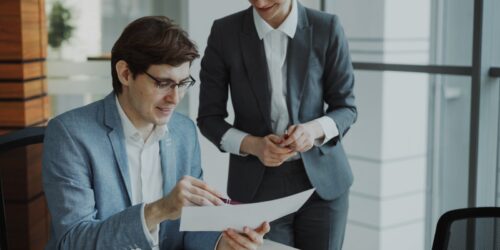 Two business professionals reviewing a managed IT services contract together at a desk