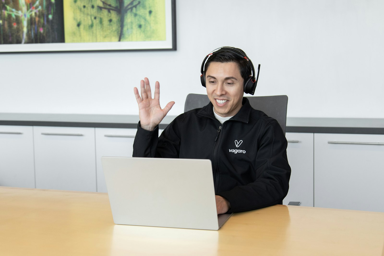 IT helpdesk technician wearing a headset providing remote support at a laptop