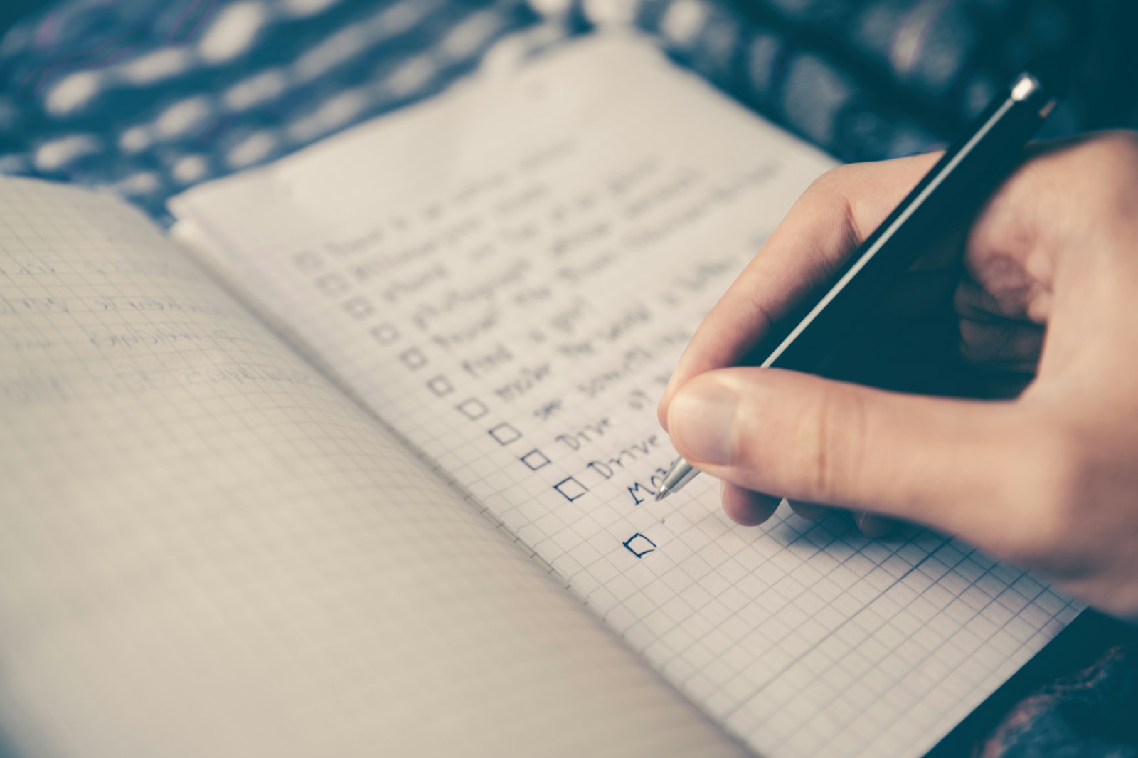 Person writing a checklist during an IT discovery and documentation phase
