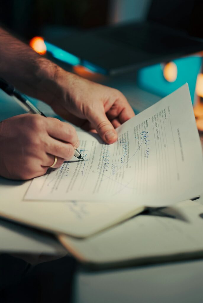 Close-up of hands signing a business services contract with a pen