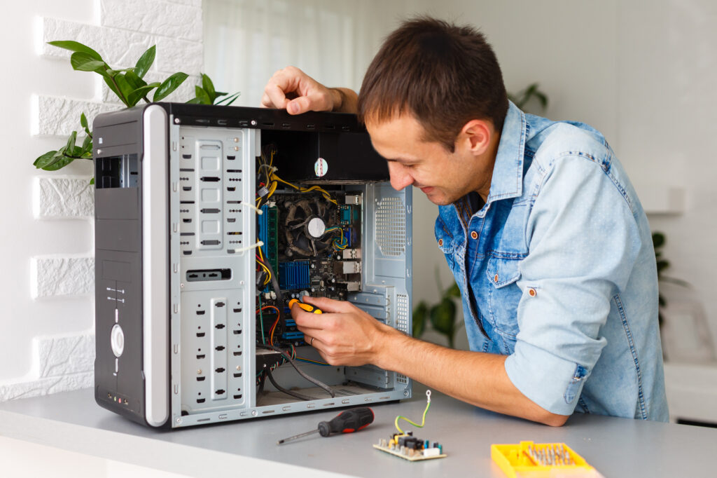 IT support technician repairing a workstation in an office