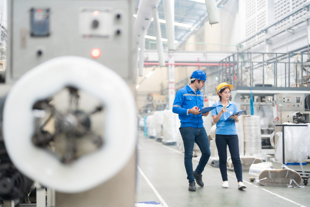 Engineer and plant manager walking a manufacturing floor checking production quality