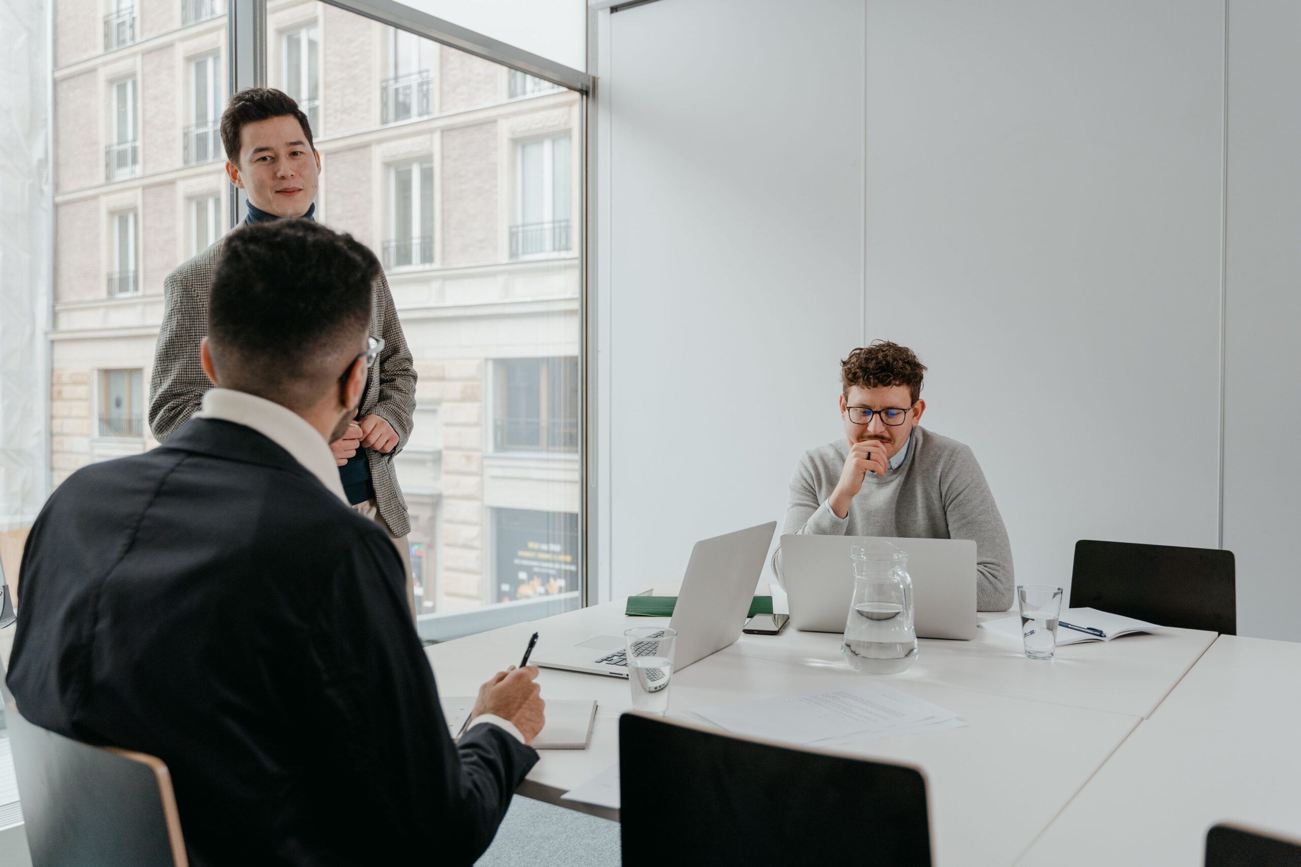 Three business colleagues in a conference room reviewing a vendor's website together before a purchase decision