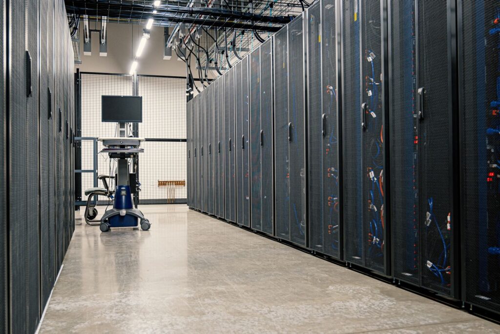 Server racks in a data center corridor, representing the backup infrastructure that should be tested on a regular schedule