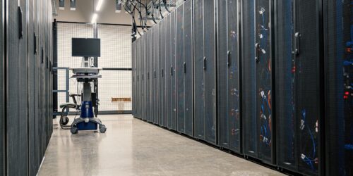 Server racks in a data center corridor, representing the backup infrastructure that should be tested on a regular schedule