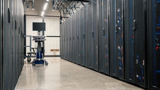 Server racks in a data center corridor, representing the backup infrastructure that should be tested on a regular schedule