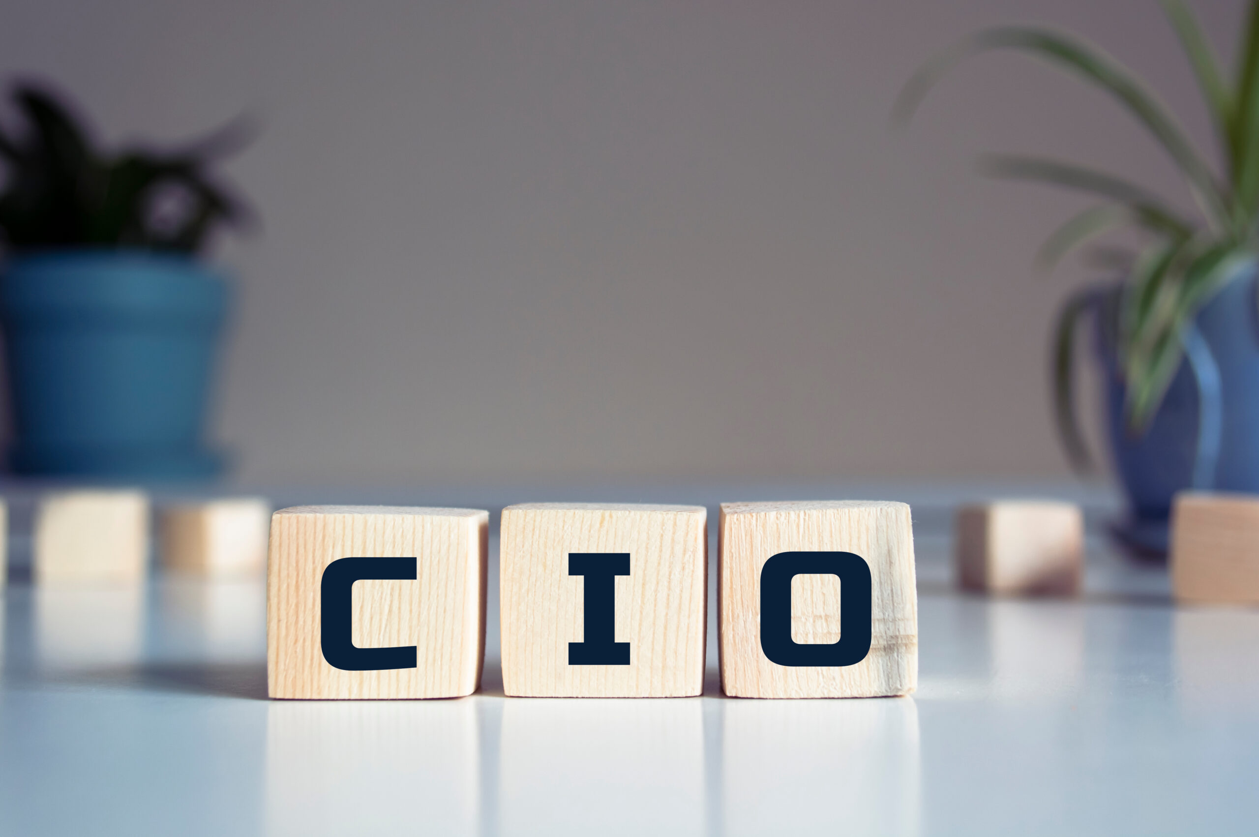 Wooden blocks spelling CIO, representing the choice between a full-time, fractional, or virtual CIO