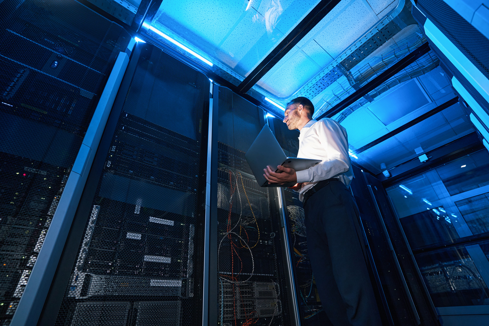 Systems administrator checking equipment inside a server cabinet during the technical review stage of a cybersecurity assessment
