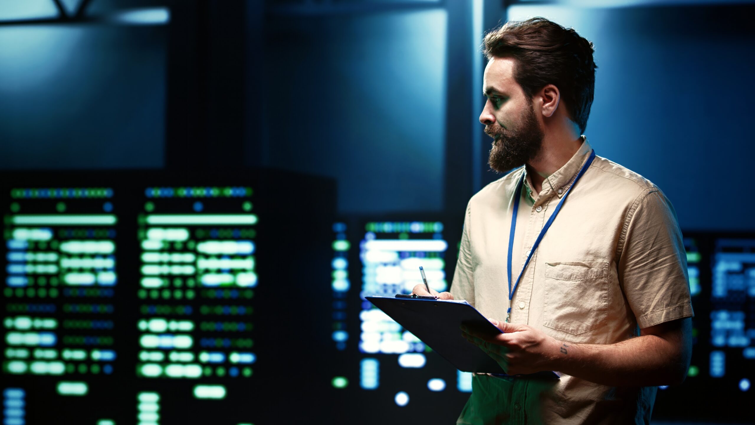 An IT specialist walking through a row of server racks in a data center, representing the infrastructure covered in a disaster recovery test