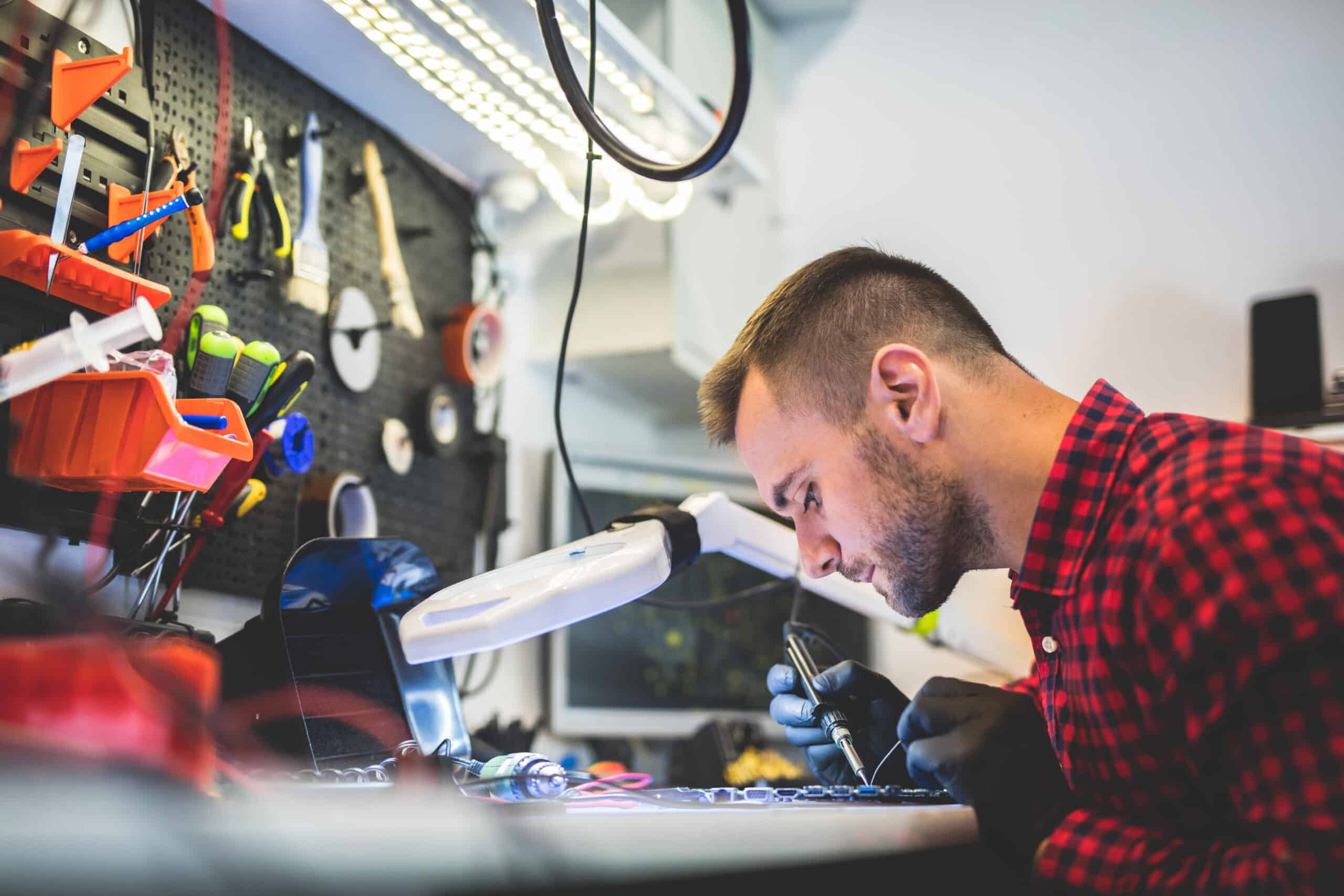IT support technician repairing computer equipment, representing ACT360 IT support services