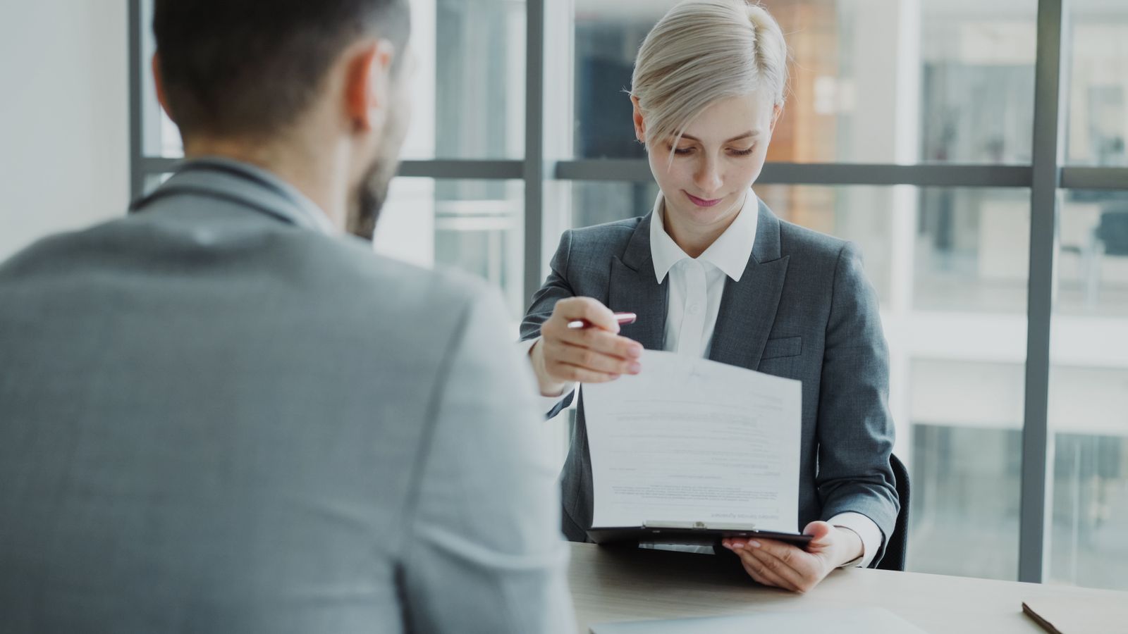 Two professionals reviewing an agreement in an office, representing a law firm comparing IT support providers before signing