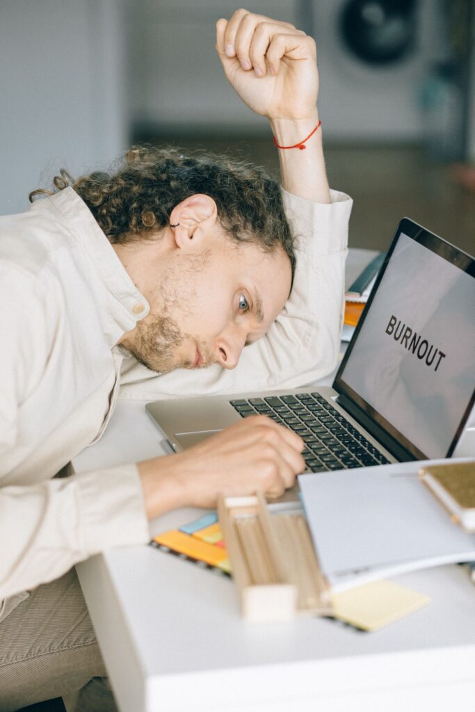 Exhausted business owner resting head on desk beside a laptop, representing the frustration of being underserved by an outgrown IT provider