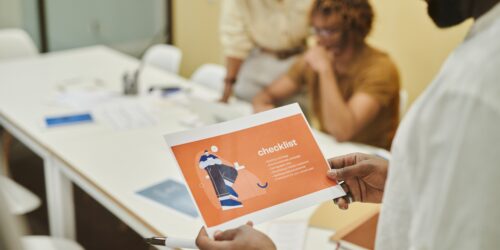 Small business team reviewing a process checklist together in a meeting before deciding what to automate