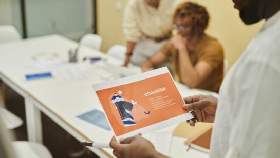 Small business team reviewing a process checklist together in a meeting before deciding what to automate