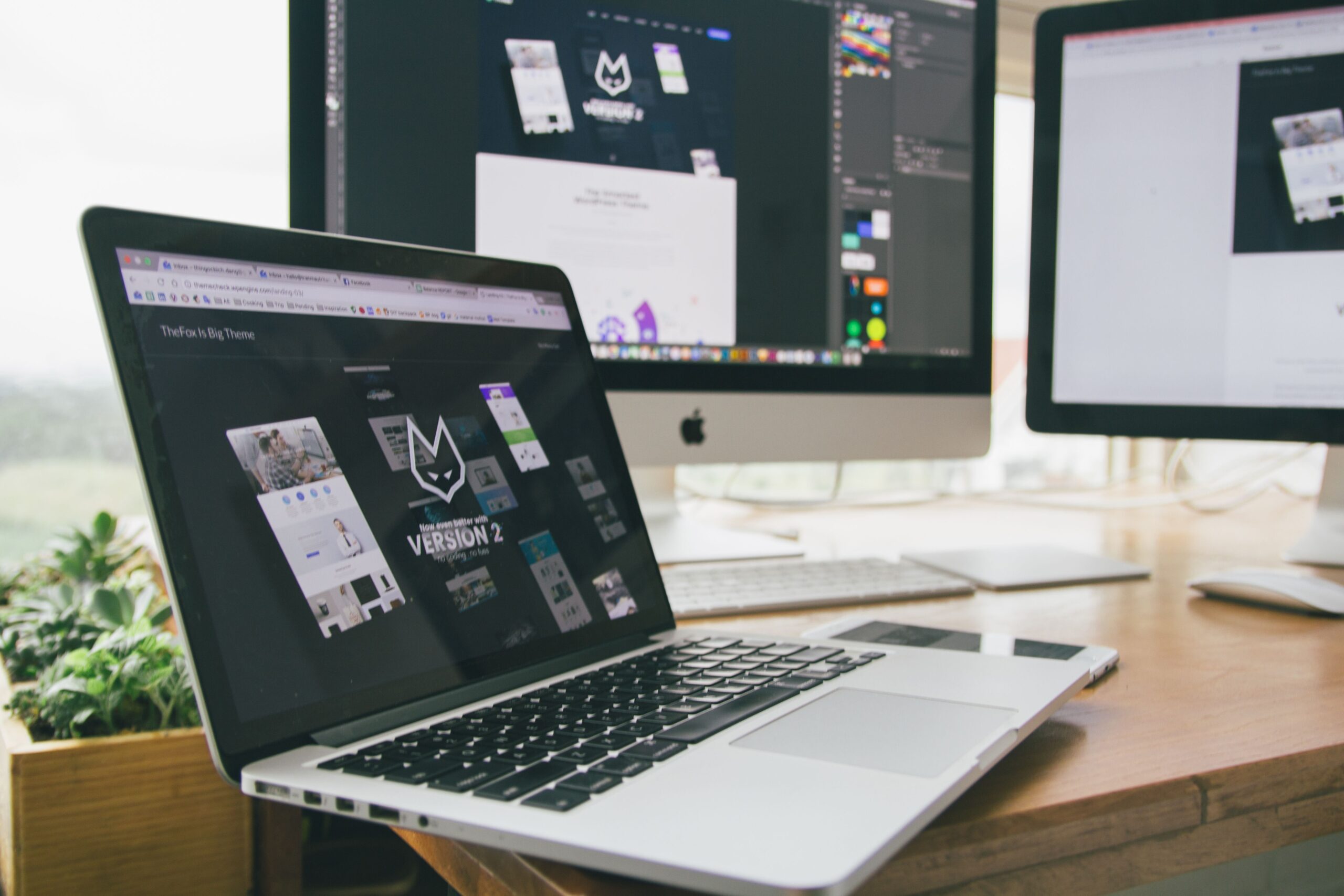 Laptop on a desk displaying a website layout during a design review