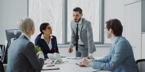 Small business owner and team reviewing growth plans around a conference table