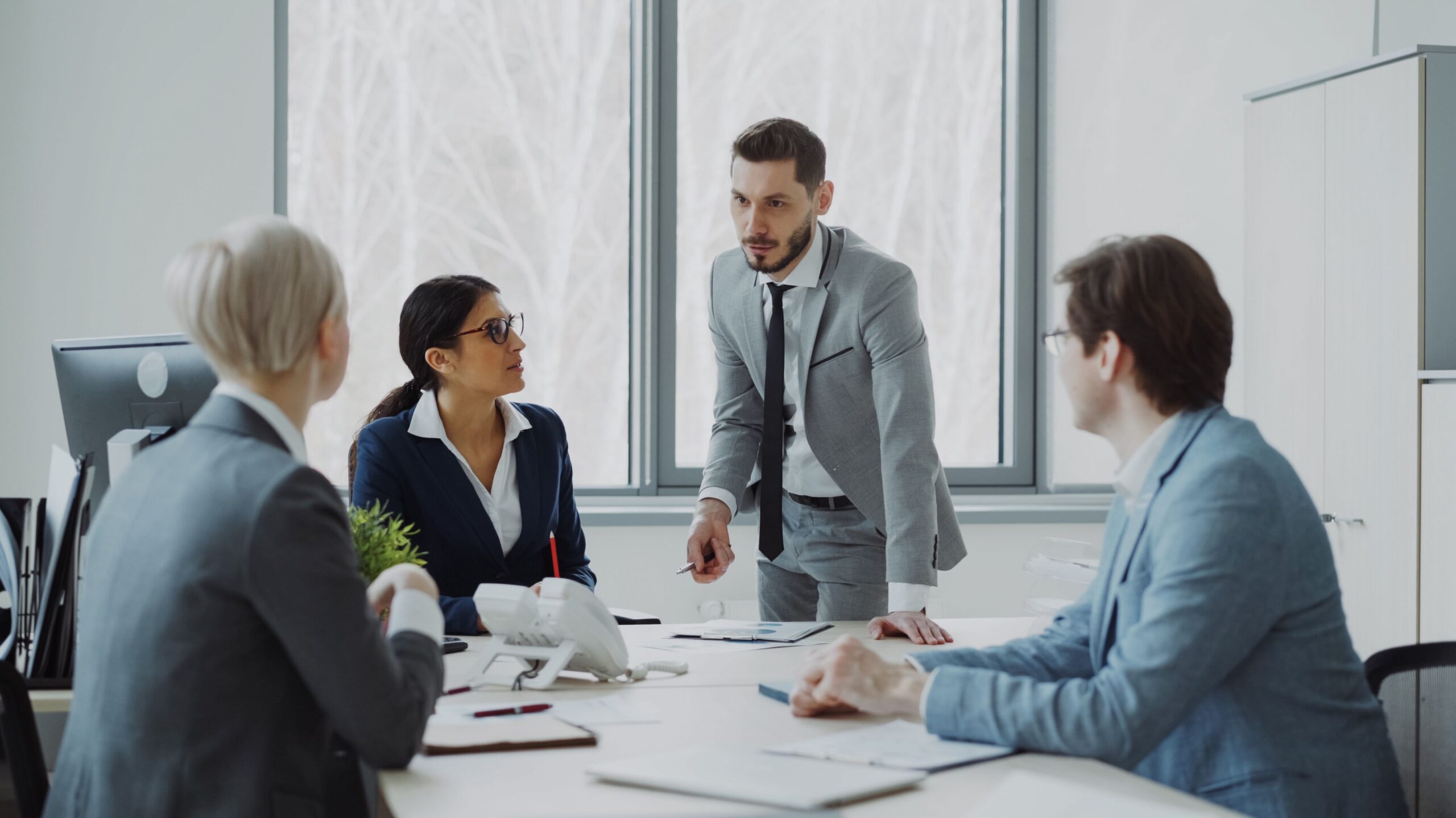 Small business owner and team reviewing growth plans around a conference table