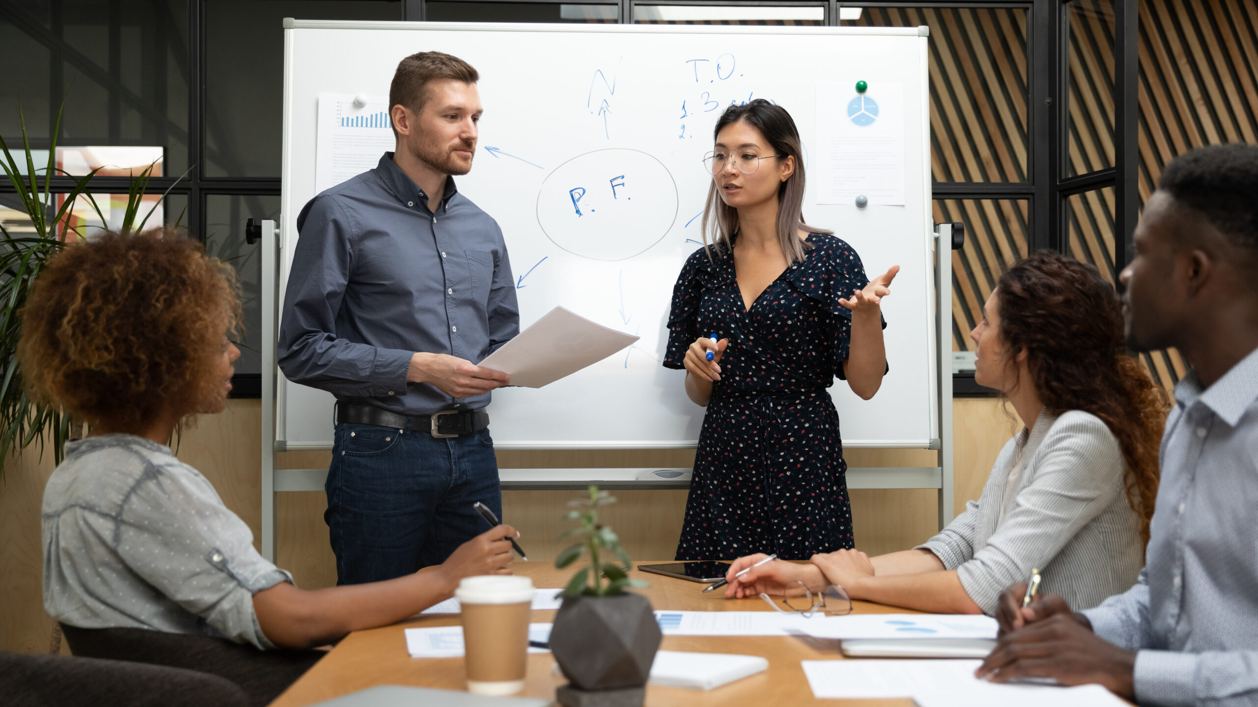 Technology advisor walking a leadership team through a multi-year IT roadmap on a whiteboard