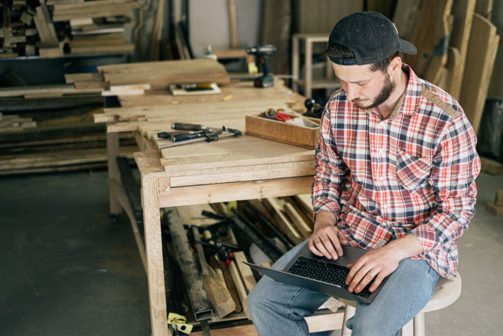 Small business owner working on a laptop in his shop, representing AI automation built around how a small business actually runs