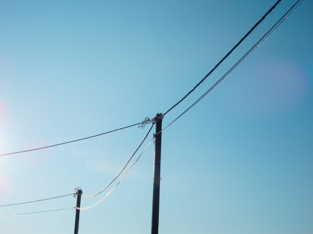 Ice-coated power lines on utility poles after a freezing rain storm, a reminder that business systems need a plan for long outages