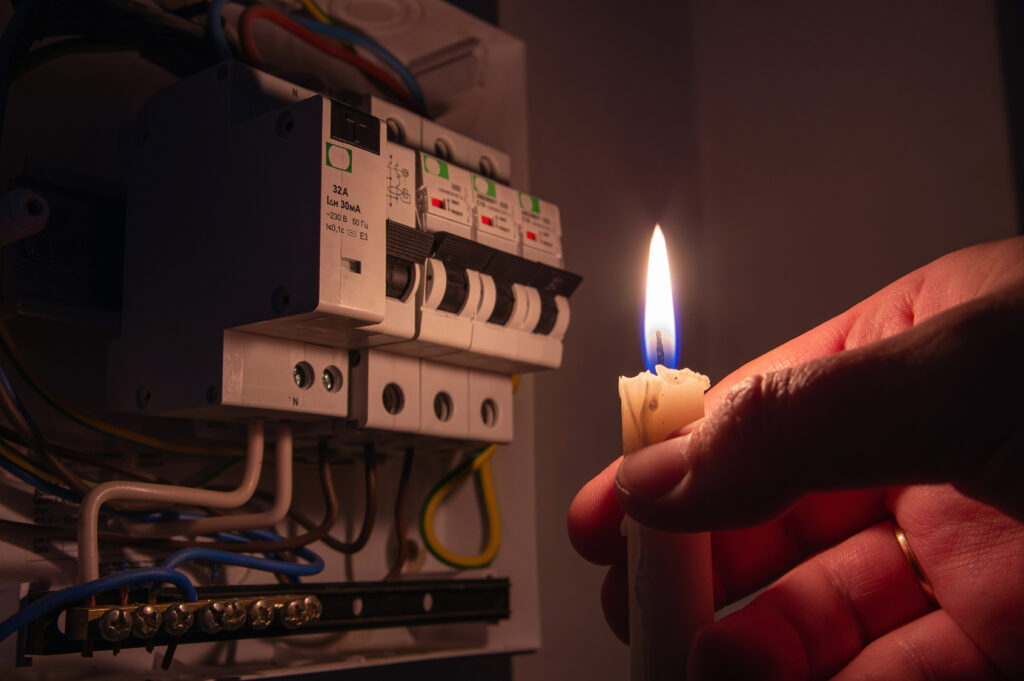Candle burning next to an electrical panel during a power outage, the moment a business continuity plan gets tested