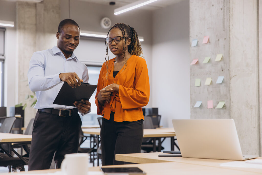 Two colleagues working through a plan with a clipboard and sticky notes, deciding how the business keeps running during an outage