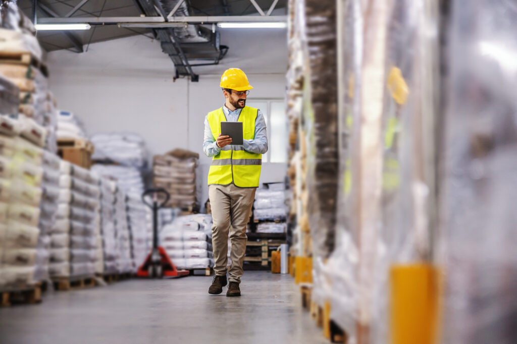Warehouse supervisor checking inventory on a tablet, the kind of system a growing operation's IT lead has to keep running