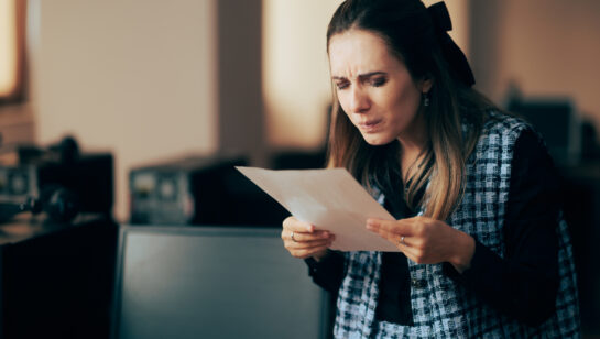 Woman squinting at the fine print of a contract, representing the lock-in clauses hidden in managed IT agreements
