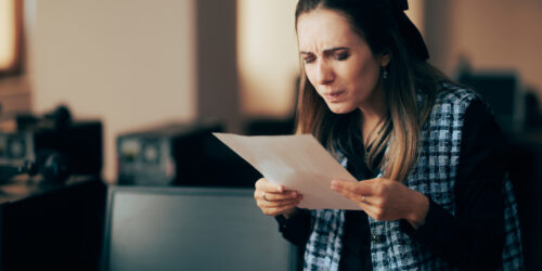 Woman squinting at the fine print of a contract, representing the lock-in clauses hidden in managed IT agreements