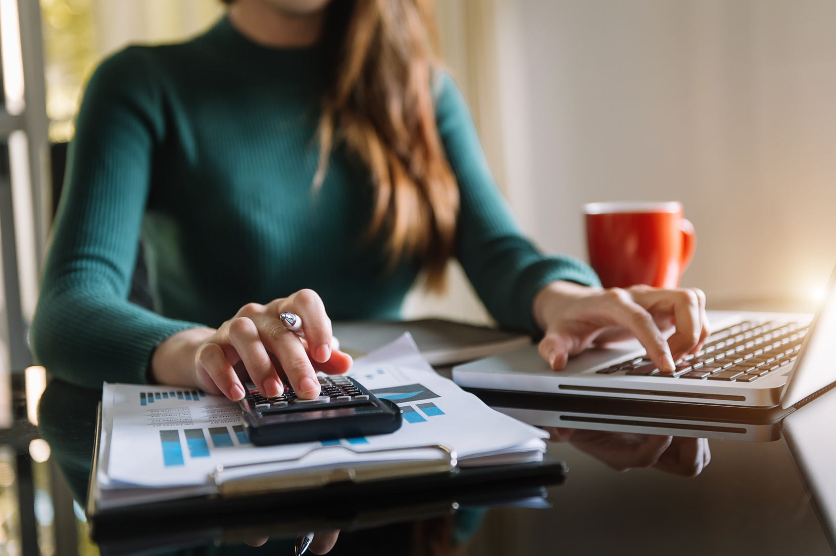 Newmarket business owner working out monthly managed IT costs with a calculator at his desk