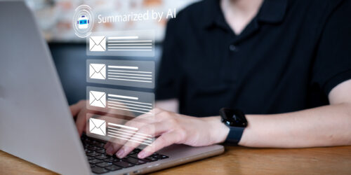Business professional at a laptop using an AI assistant to summarize a busy email inbox