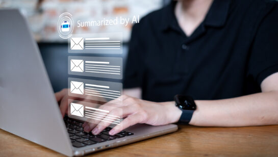 Business professional at a laptop using an AI assistant to summarize a busy email inbox