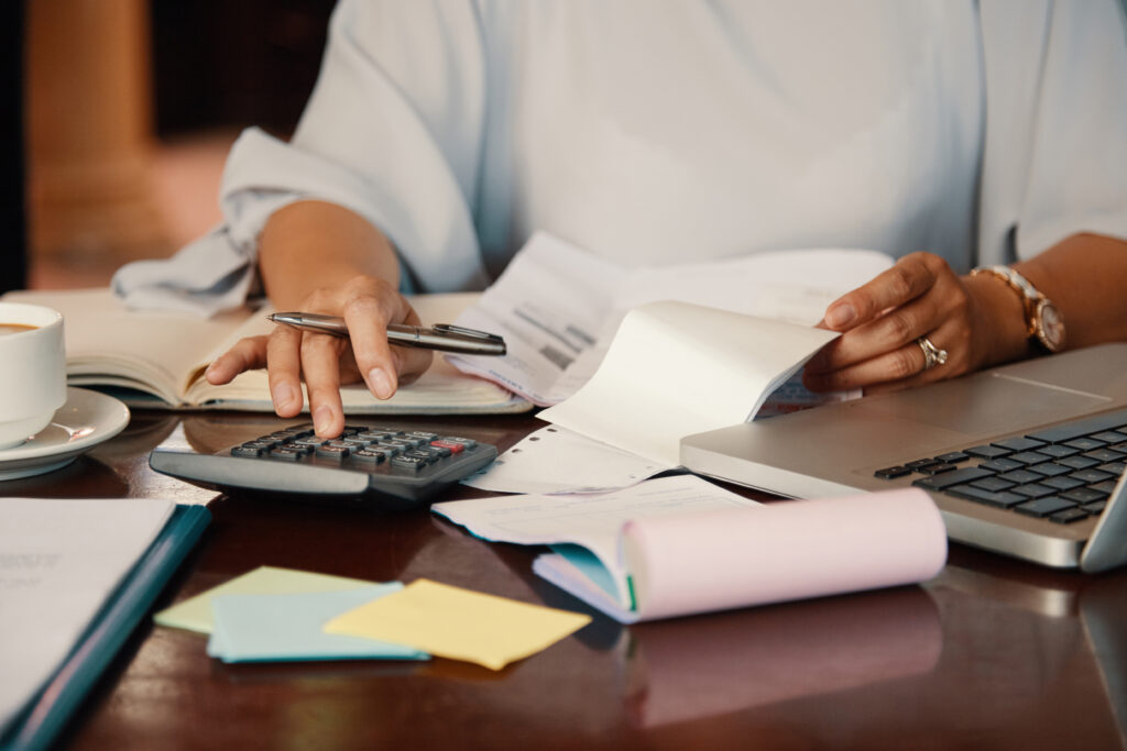 Small business owner working through bills and service paperwork at her desk, checking what an IT support contract actually covers