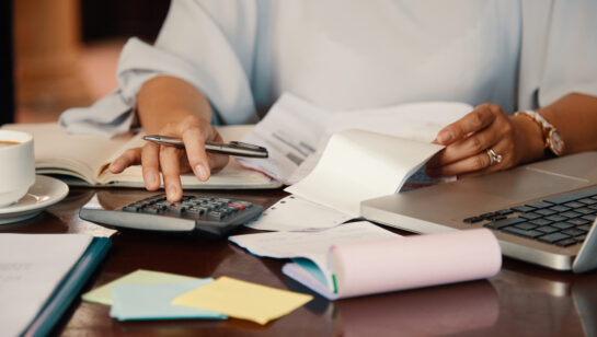 Small business owner working through bills and service paperwork at her desk, checking what an IT support contract actually covers